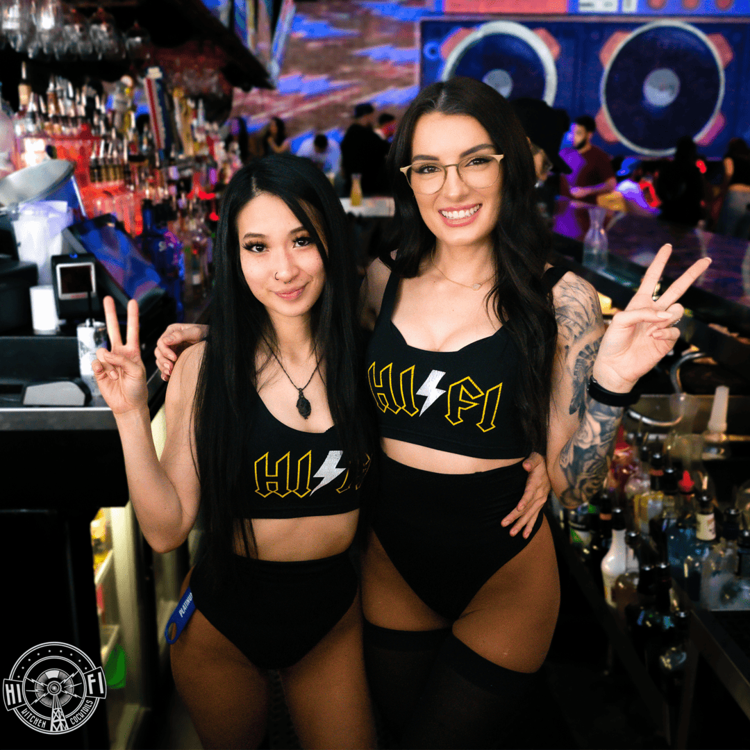 Two female HiFi bartenders posing with peace signs.